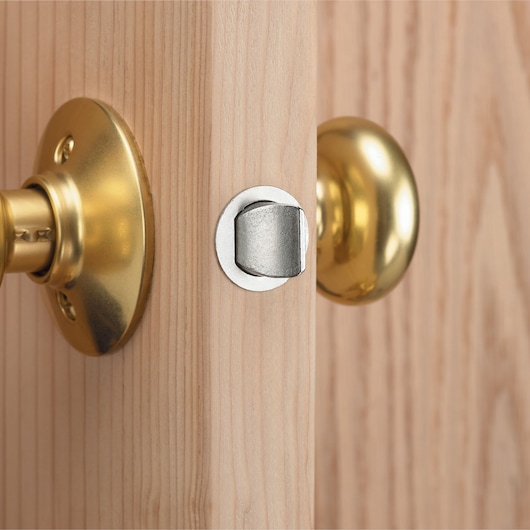 Close-up view of a wooden door with a brass door knob and a silver latch.