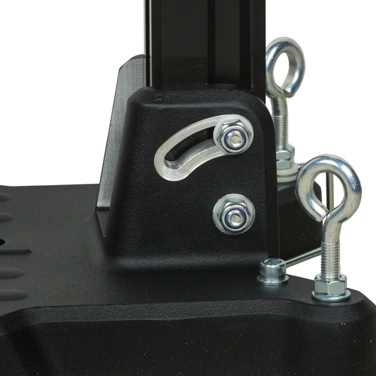 Close-up of a black metal base with silver bolts and eye bolts attached, part of a photography equipment mount.