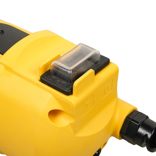 Close-up of a yellow DEWALT power tool, showing its clear plastic switch cover and labeled on/off button.