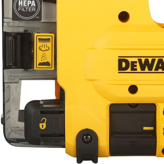 Close-up view of a DEWALT tool, showing a yellow plastic housing with the DEWALT logo, a HEPA filter label, and a warning sticker. The image highlights a locking mechanism and dust extraction feature as part of a photography product in the DEWALT D25304DH range.