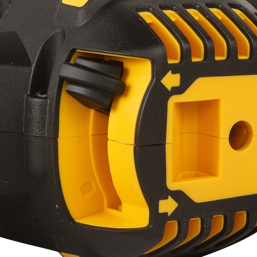 Close-up view of a DEWALT power tool, showing a yellow and black plastic housing with vent grooves, a ridged control switch, and an arrow indicator.