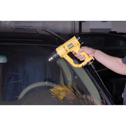 Photo of DEWALT heat gun in use on car window, SKUs D26411, D26411-B2, D26411-B3, D26411-QS, D26411-B2C, D26411-BR.