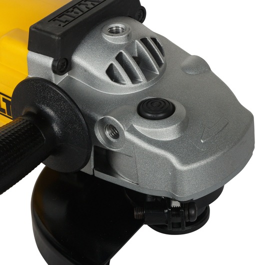 Close-up view of a DEWALT angle grinder, showing its metal housing, side handle, and part of the guard.