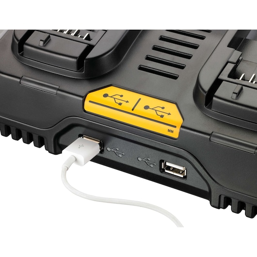 Close-up view of a DEWALT battery charger (model DCB102) showing its USB charging port with a white USB cable plugged in.