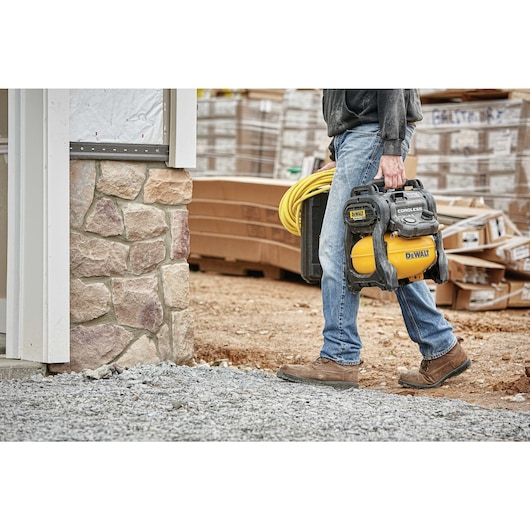 FLEXVOLT® 2.5 GALLON CORDLESS AIR COMPRESSOR being carried by a person, ready for use