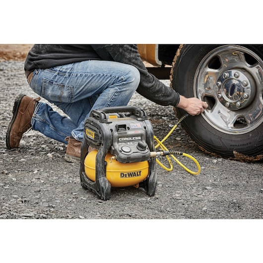 FLEXVOLT® 2.5 GALLON CORDLESS AIR COMPRESSOR being used by a person to inflate a tire tube