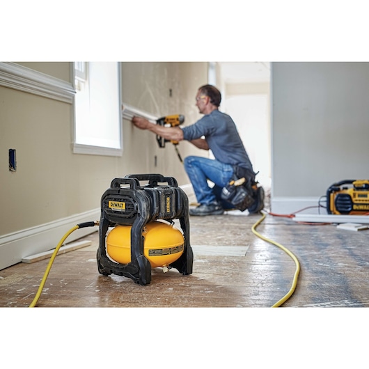 FLEXVOLT® 2.5 GALLON CORDLESS AIR COMPRESSOR being used by a worker for pneumatic fastening