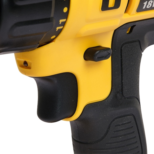 Close-up of a DEWALT cordless drill handle showing the trigger and direction switch, displaying yellow and black color details.