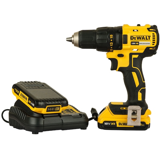 A DEWALT 18V XR cordless drill with a yellow and black body, shown next to its battery charger. The drill has a brushless motor and a metal belt clip attached to the base.