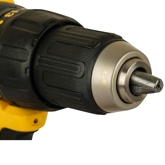 Close-up view of the front section of a cordless drill, showing the chuck and bit. The drill has a black and yellow design.