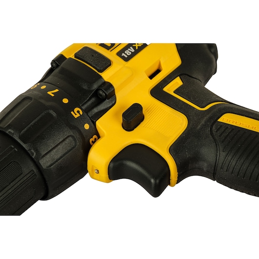 Close-up of a yellow and black DEWALT 18V cordless drill handle and trigger, highlighting the torque adjustment ring and ergonomic grip.