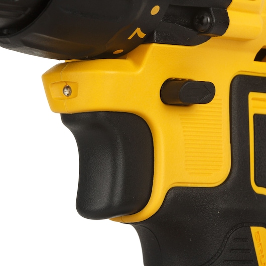 Close-up view of the handle and trigger of a yellow and black DEWALT power drill, focusing on the grip and forward/reverse switch.