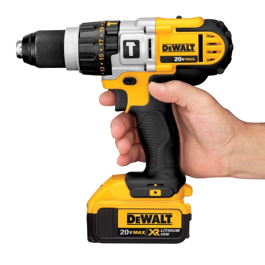 A hand holding a DEWALT 20V MAX cordless drill with a lithium-ion battery, featuring a black and yellow design.
