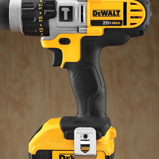 Close-up of a DEWALT 20V MAX cordless drill showing its handle, trigger, and part of the battery. The drill features black and yellow colors with visible branding and a metal belt clip.