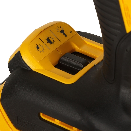 Close-up image of the DEWALT DCD996P2 cordless drill showing the control switch for adjusting the built-in LED work light brightness, with three light level icons.