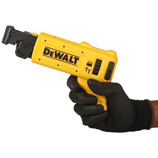 A gloved hand holding a yellow DEWALT DCF6201-XJ tool attachment, designed for use with power tools.