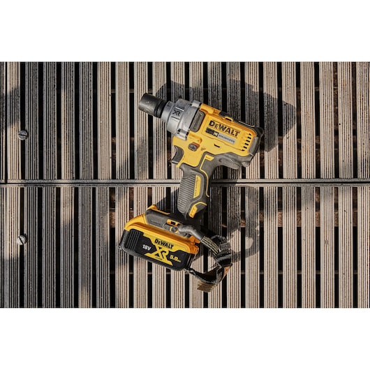 A DEWALT cordless impact wrench, model DCF894P2, with an 18V XR 5.0Ah battery, placed on wooden slats.