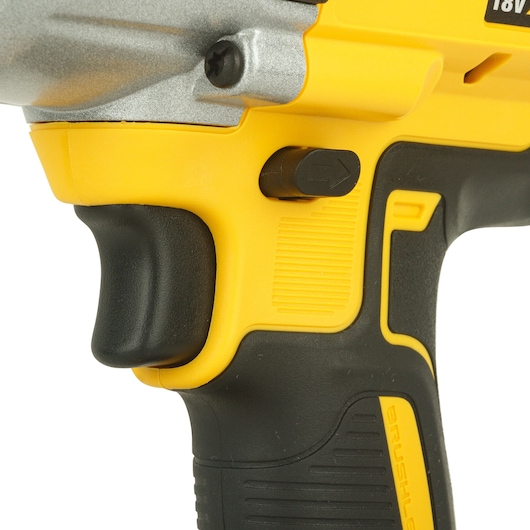 Close-up of a yellow and black DEWALT cordless power tool handle, showing the trigger, grip, and directional switch.