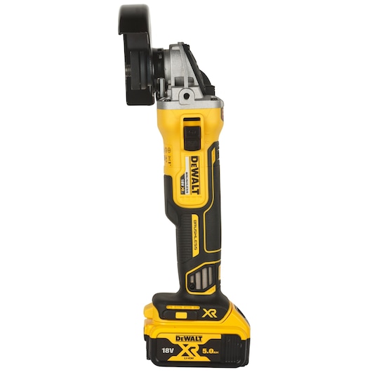 Side view of a DEWALT cordless angle grinder with a yellow and black body, equipped with an 18V XR 5.0Ah lithium-ion battery.