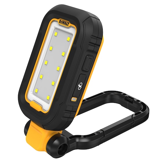 A DEWALT portable LED work light, model DCL182-KR, with a rugged black and yellow casing. The light features a rectangular LED panel with multiple small yellow LEDs and an adjustable, foldable stand for versatile positioning. It is designed for photography and worksite illumination.