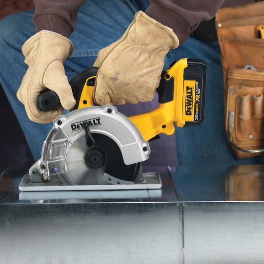 Lithium Ion Metal Cutting Circular Saw being used by person on metal surface