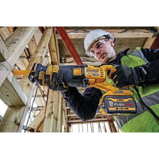 FLEXVOLT brushless cordless reciprocating saw being used by person on wood.