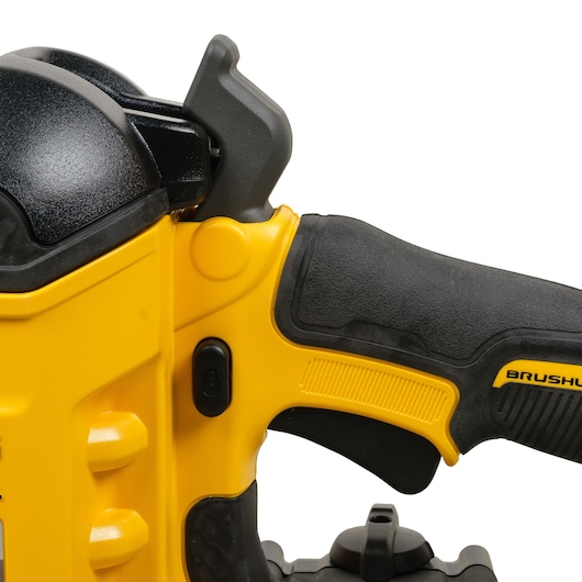 Close-up view of a DEWALT power tool grip, showing the black and yellow handle with a brushless marking, textured rubber surface, and control switch.