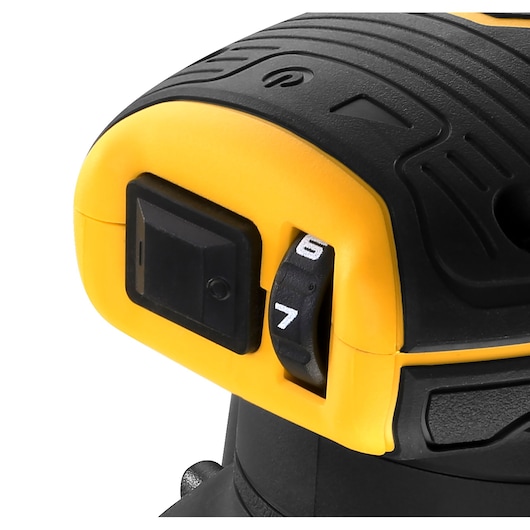 Close-up of the speed control and power switch on a DEWALT power tool, showing a black switch and a numbered dial set between 6 and 7, with a yellow and black casing.