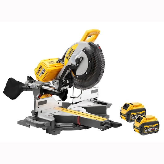 A DEWALT sliding compound miter saw with a yellow and black design, shown with two removable batteries. The saw is placed on a flat surface and includes a dust collection bag attached at the back.