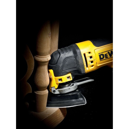 DEWALT multitool sanding wooden furniture in a close-up view, showing detail and precision work.