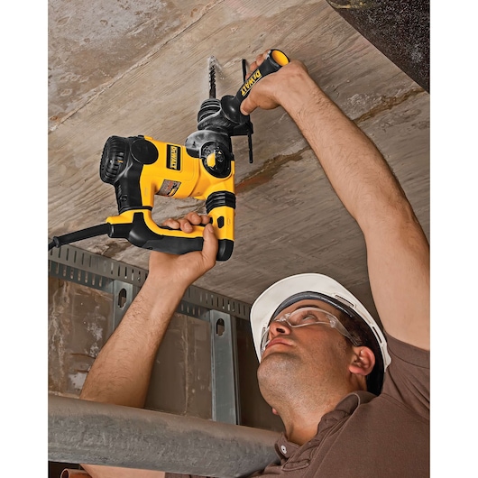 DEWALT DT8912, DT8912-QZ used for drilling in ceiling. Construction worker uses yellow power tool. Photography category.