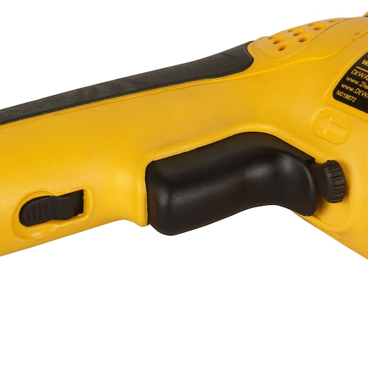 Close-up of the handle and control switch of a yellow DEWALT power tool.