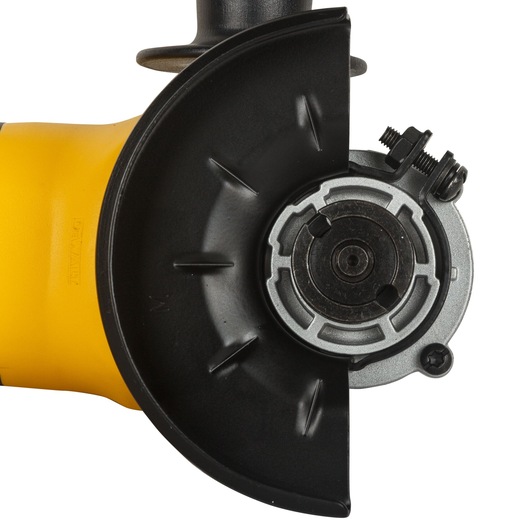 Close-up view of a DEWALT DW803 angle grinder, showing the metal guard and spindle assembly used for attaching grinding or cutting discs.