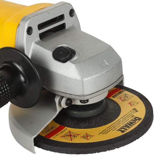 Close-up of a DEWALT branded angle grinder with a protective guard and a black handle. The grinder has a yellow and metallic silver body and a DEWALT labeled abrasive disc.