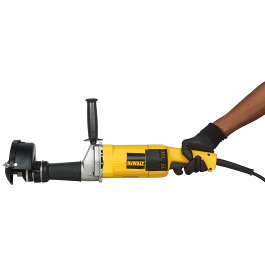 A person wearing a black glove is holding a yellow DEWALT DW882 power tool, specifically a grinder, against a white background.