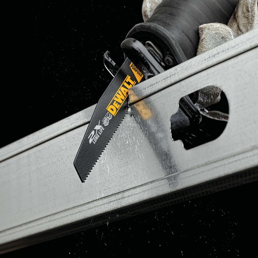 A close-up of a DEWALT reciprocating saw blade cutting through a metal beam. The blade has branding and indicates it is designed for long life and multipurpose use.