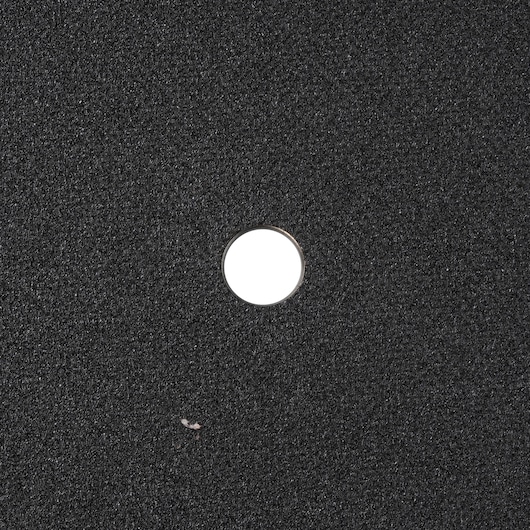 Photo of DEWALT DWA8011R black abrasive disc with center hole, top view.