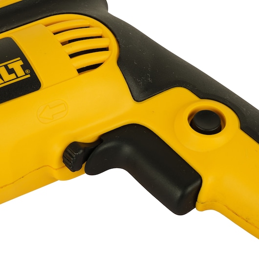 Close-up view of a DEWALT electric drill handle, showing the yellow and black trigger, button, and air vent.
