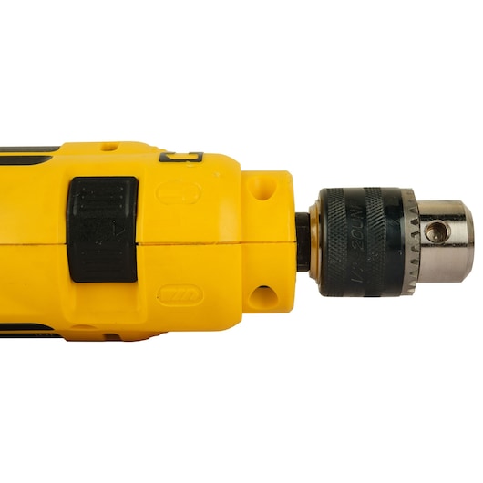 Close-up view of the front section of a yellow DEWALT electric drill, showing the chuck and speed control switch.