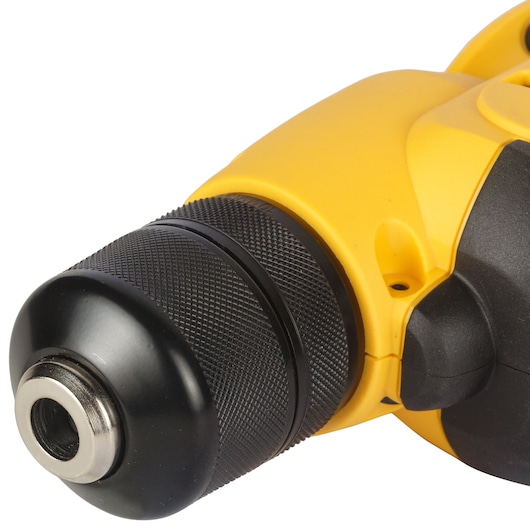 Close-up view of the front end of a yellow and black electric drill with a textured metal chuck.