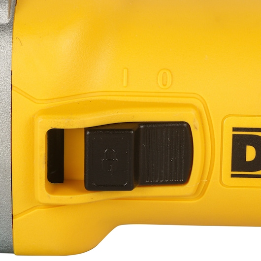 Close-up view of the yellow and black power switch of a DEWALT tool, showing the locking mechanism and '0' and 'I' power indicators.