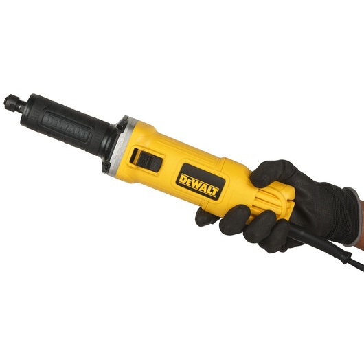 A DEWALT DWE4884 electric die grinder held in a gloved hand, featuring a yellow body and black grip with the DEWALT logo.