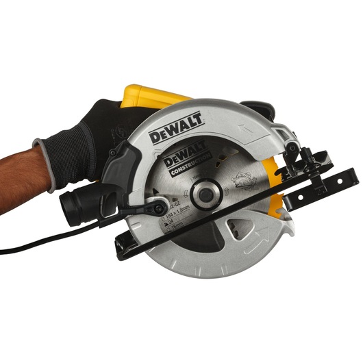 Close-up of a DEWALT DWE560B circular saw held by a person wearing a black work glove, showing the blade and handle clearly.