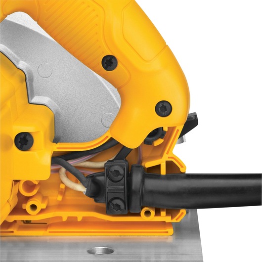 Close-up view of a yellow and black DEWALT power tool, showing the handle, part of the metal blade guard, and the power cord connection.