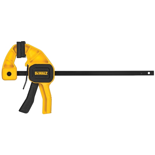 A DEWALT yellow and black bar clamp with a trigger handle used for securing objects during woodworking or photography setups.