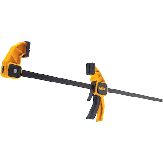 A yellow and black DEWALT bar clamp with trigger handle, used for securing materials during photography or construction.