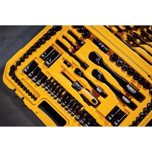 Close-up view of a DEWALT yellow tool case containing an organized set of socket wrenches, ratchets, and various drive bits, displayed neatly in their designated slots.