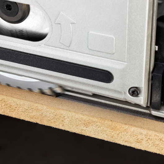 Close-up view of a DEWALT circular saw cutting through a wooden board.
