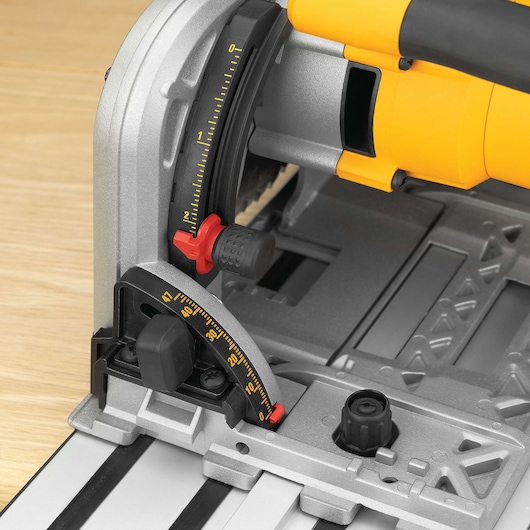 Close-up view of a DEWALT track saw showing its adjustment scale and locking mechanism. The saw features a yellow and black color scheme and precise angle measurement markings.