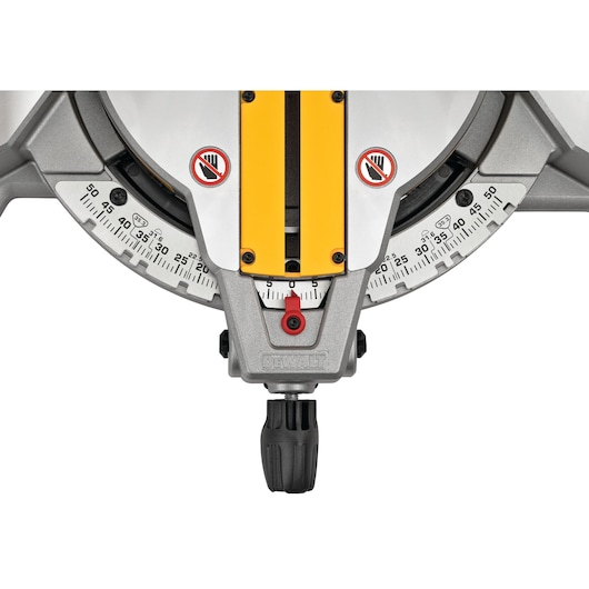 Close-up view of the angle adjustment gauge and handle of a DEWALT DWS713 compound miter saw, showing detailed markings for precise cutting angles and safety warning symbols.